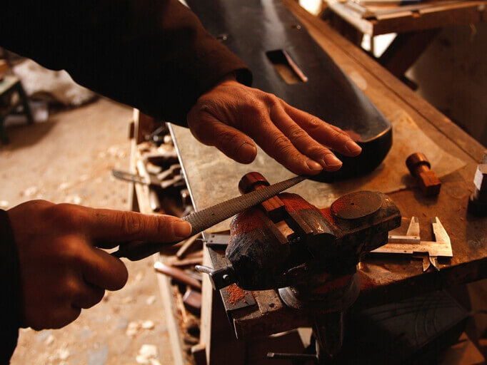 un artesano marroquí trabajando la madera en su taller